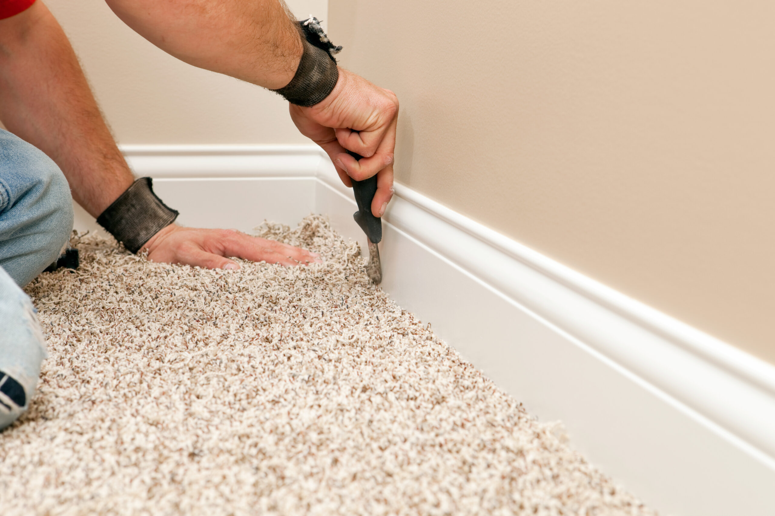 Installer Using Carpet Knife to Tuck New Floor